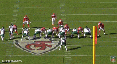 A Group Of Football Players Are On A Field With The Number 14 In The Foreground GIF
