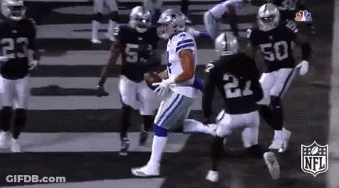 A Group Of Football Players Are Playing A Game Of Football . GIF
