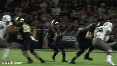 A Group Of Football Players Are Playing A Game Of Football . GIF