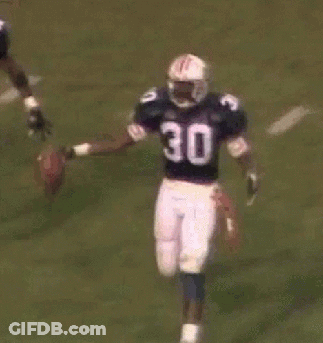 A Group Of Football Players Are Playing A Game Of Football . GIF