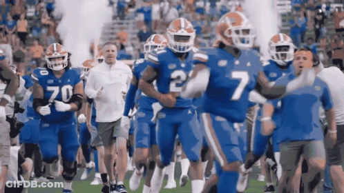 A Group Of Football Players Are Running On A Field And One Of Them Has The Number 7 On His Jersey GIF