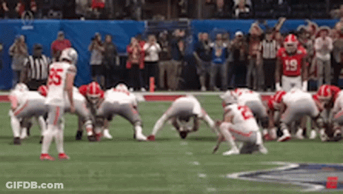 A Group Of Football Players Are Squatting On The Field . One Of The Players Has The Number 55 On His Jersey . GIF