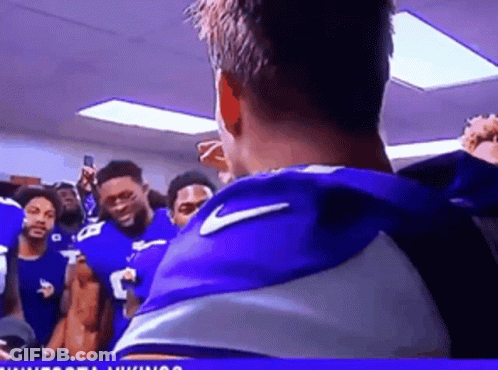 A Group Of Football Players Are Standing In A Locker Room GIF