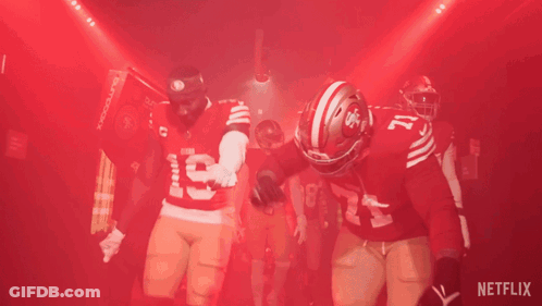 A Group Of Football Players Are Standing In A Tunnel With A Netflix Logo In The Background GIF