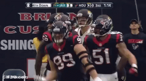 A Group Of Football Players Are Standing In Front Of A Sign That Says ' Brig Cus Shing ' GIF