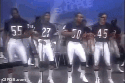 A Group Of Football Players Are Standing Next To Each Other In A Line . GIF