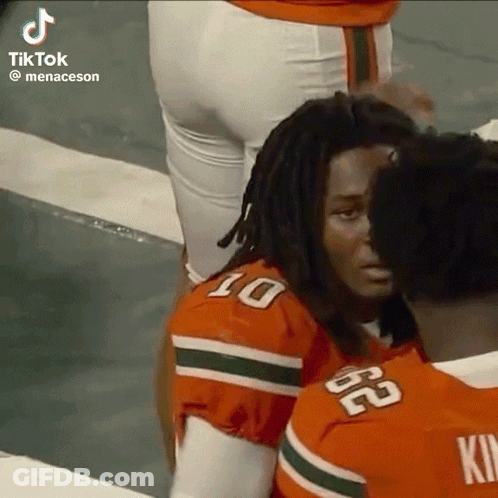 A Group Of Football Players Are Standing Next To Each Other On A Field . GIF