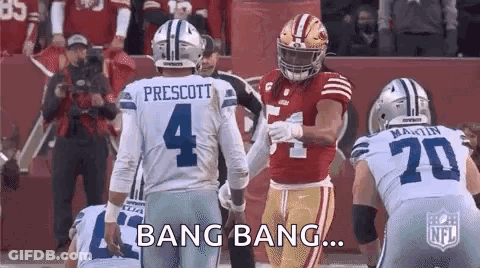A Group Of Football Players Are Standing Next To Each Other On A Field And One Of Them Is Holding The Hand Of Another Pl GIF