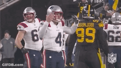 A Group Of Football Players Are Standing On A Field And One Of Them Is Wearing A Jersey With The Number 39 On It . GIF