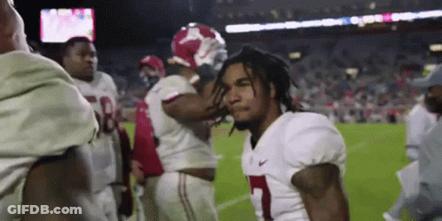 A Group Of Football Players Are Standing On A Field And One Of Them Is Wearing A Number 1 Jersey . GIF