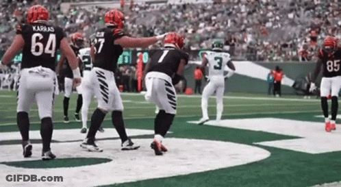 A Group Of Football Players Are Standing On A Field . One Of The Players Has The Number 7 On His Jersey . GIF