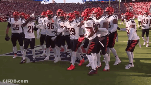 A Group Of Football Players Are Standing On A Field With One Wearing The Number 21 GIF