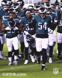 A Group Of Football Players Are Walking On A Field With The Number 54 On Their Jersey GIF