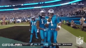 A Group Of Football Players In Blue Uniforms Are Standing On A Field GIF