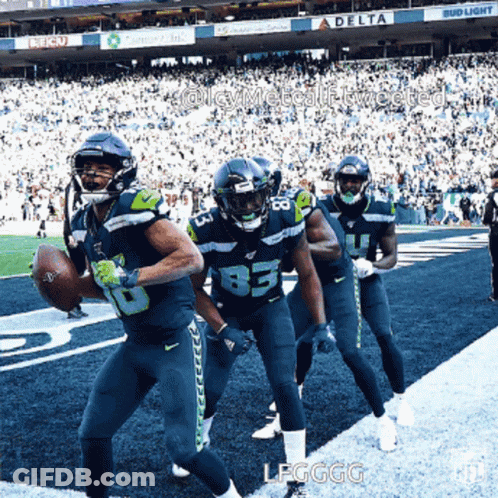 A Group Of Football Players On A Field With A Bud Light Sign In The Background GIF