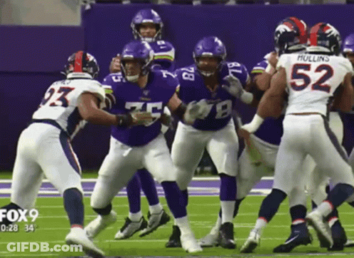 A Group Of Football Players On A Field With One Wearing The Number 52 GIF
