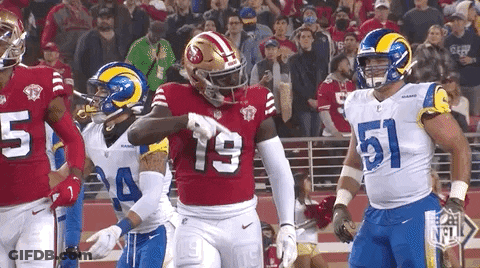 A Group Of Football Players Standing On A Field . GIF