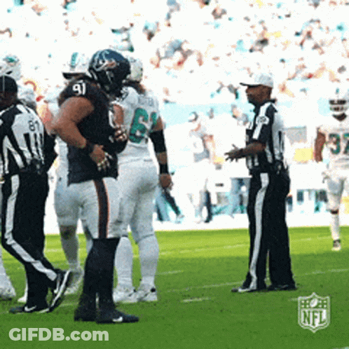 A Group Of Football Players Standing On A Field With A Referee And A Nfl Logo In The Background GIF