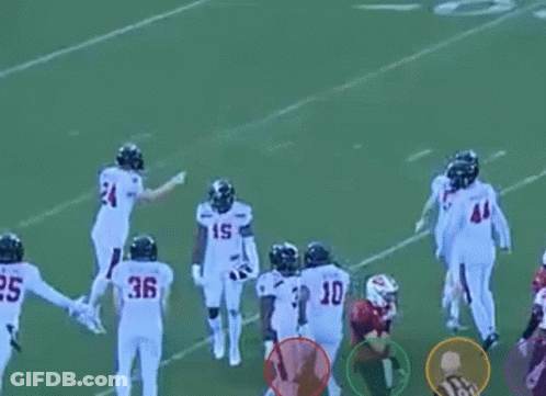 A Group Of Football Players Standing On A Field . GIF