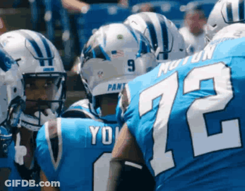 A Group Of Football Players Wearing Blue Uniforms With The Number 72 On Them GIF