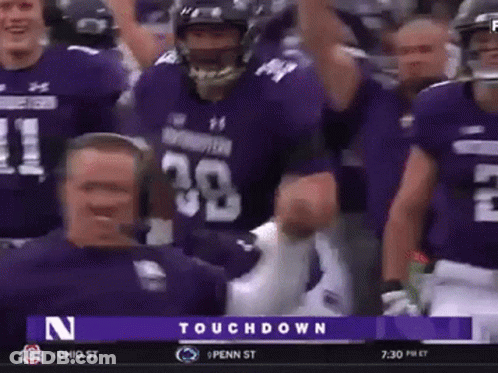 A Group Of Football Players Wearing Purple Uniforms Are Celebrating A Touchdown Against Penn State GIF