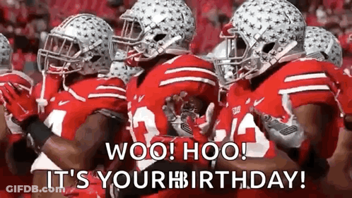 A Group Of Football Players Wearing Red Uniforms And Helmets Are Standing Next To Each Other On A Field . GIF