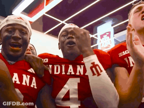 A Group Of Football Players Wearing Red Uniforms With The Number 4 On Them GIF