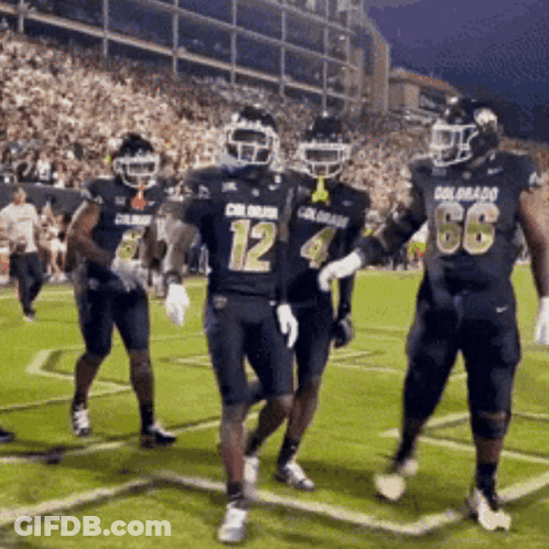 A Group Of Football Players Wearing Uniforms That Say Colorado Are Running On The Field GIF