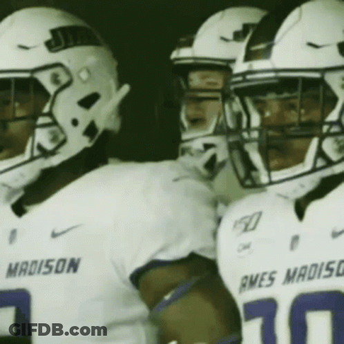 A Group Of Football Players Wearing White Uniforms With The Word Madison On The Front GIF