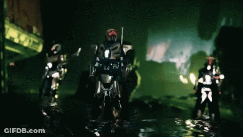 A Group Of Futuristic Soldiers Are Standing In A Dark Area GIF