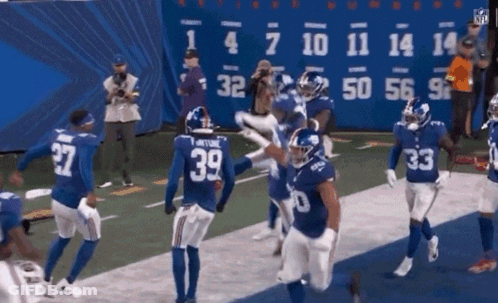A Group Of Giants Football Players Celebrate A Touchdown GIF
