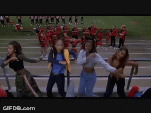 A Group Of Girls Are Dancing In A Stadium While Watching A Football Game . GIF