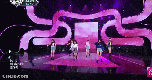 A Group Of Girls Are Dancing On A Stage With A Purple Background GIF