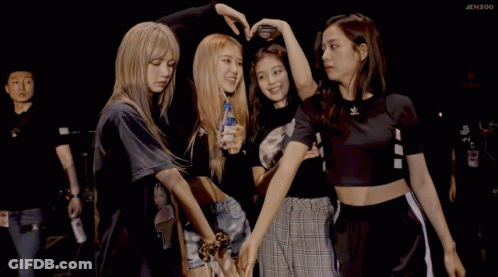 A Group Of Girls Are Posing For A Picture And One Of Them Is Holding A Bottle Of Water GIF
