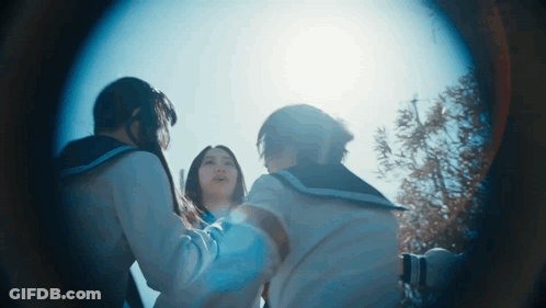 A Group Of Girls Are Standing In A Circle Looking At The Sun GIF
