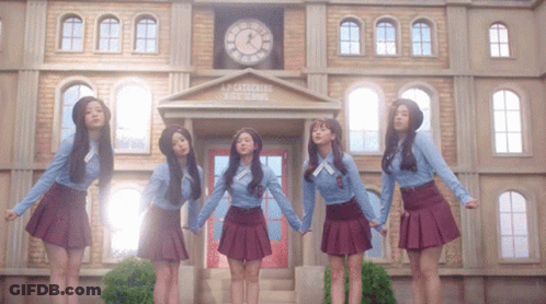 A Group Of Girls Are Standing In Front Of A Building That Says L.p. Cathedral High School GIF