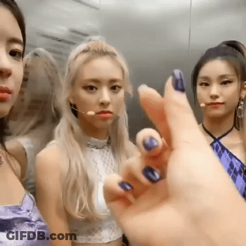 A Group Of Girls Are Standing Next To Each Other In An Elevator . One Of The Girls Is Wearing A Purple Dress . GIF
