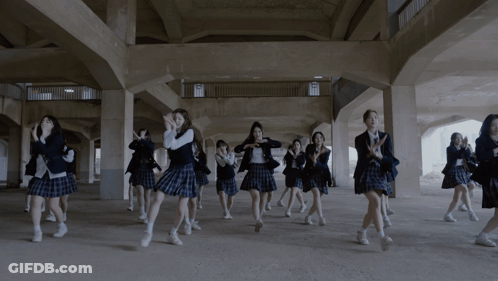 A Group Of Girls In School Uniforms Are Dancing In A Dark Hallway GIF