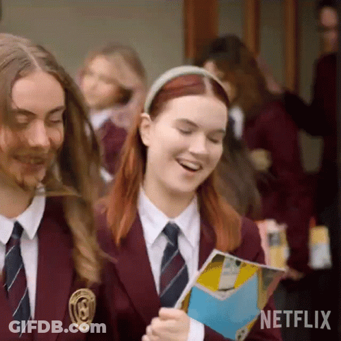 A Group Of Girls In School Uniforms Are Walking Down A Hallway And Smiling . GIF