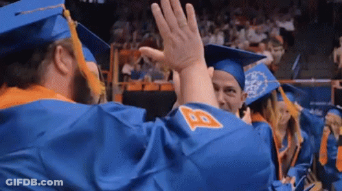 A Group Of Graduates Are Giving Each Other A High Five . GIF