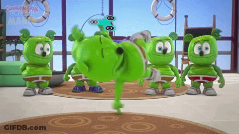 A Group Of Gummy Bears Are Standing In A Room And One Is Doing A Trick GIF