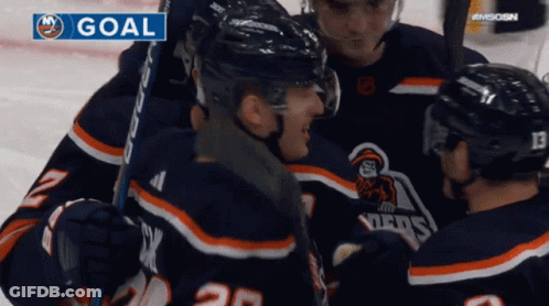 A Group Of Hockey Players Are Celebrating A Goal On A Screen GIF