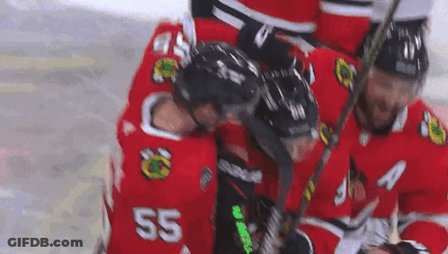 A Group Of Hockey Players Are Huddled Together On The Ice . One Of The Players Has The Number 55 On His Jersey . GIF