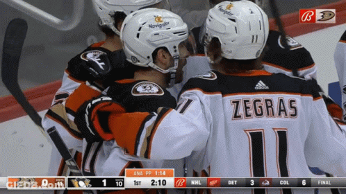 A Group Of Hockey Players Are Huddled Together With One Wearing A Jersey That Says Zegras GIF