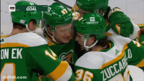 A Group Of Hockey Players Are Huddled Together With One Wearing The Number 36 On His Back GIF