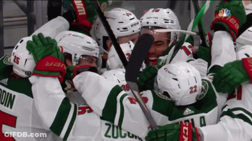 A Group Of Hockey Players Are Hugging Each Other And One Of The Players Has The Number 23 On His Jersey GIF