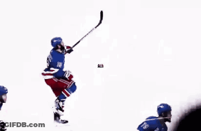 A Group Of Hockey Players Are Playing A Game On The Ice While A Referee Looks On . GIF
