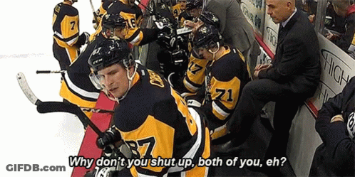 A Group Of Hockey Players Are Sitting On A Bench And One Of Them Is Wearing A Jersey With The Number 71 On It . GIF