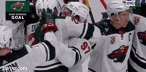 A Group Of Hockey Players Are Standing Next To Each Other . GIF