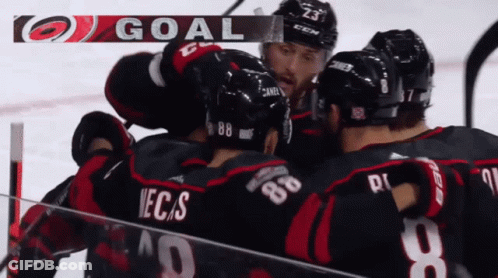 A Group Of Hockey Players Celebrate A Goal With The Letters Goal Above Them GIF